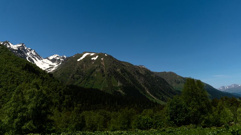 Majestic snow-capped mountain peaks and lush green valley
