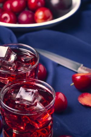 Red beverage near fresh fruits on cloth