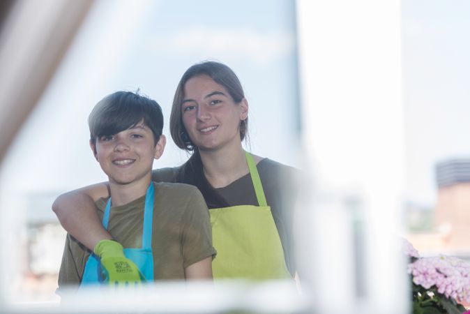 Two happy teenager on patio posing while gardening