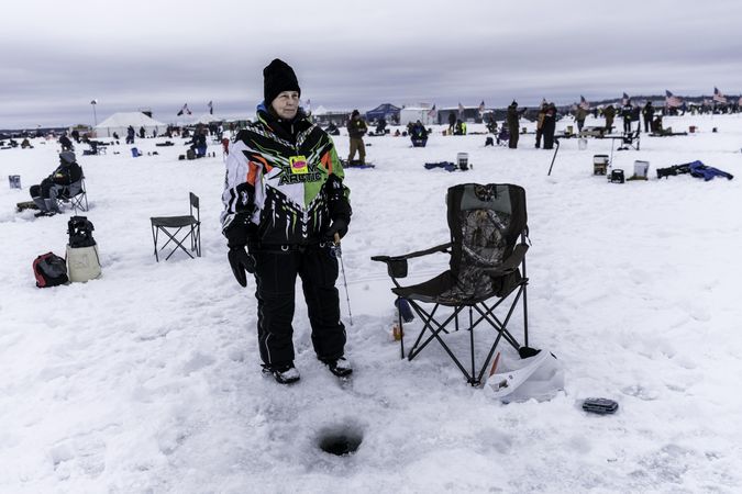 Nisswa, MN, USA - January 25th, 2020: Woman standing at her ice fishing hole