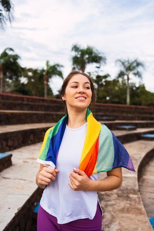 Smiling sportswoman with a towel outdoors on sunny day