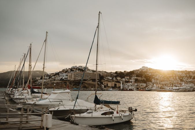 Yachts docked in sea port at sunset