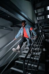 Young man jumping downstairs in building