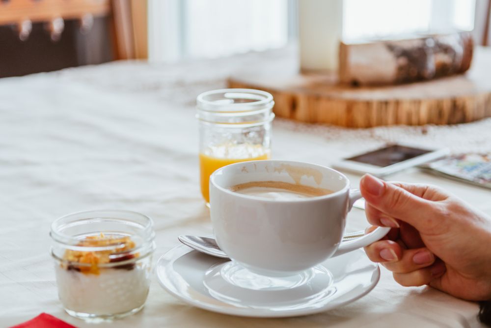 Person drinking cappuccino and having a breakfast