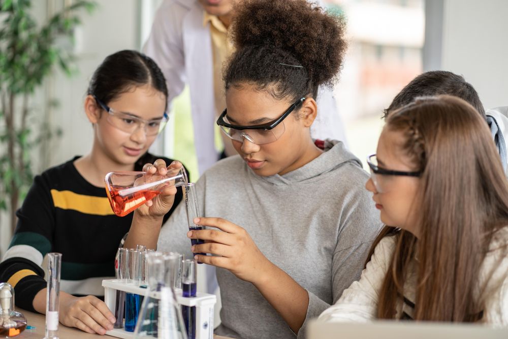 Multi-ethnic female students in science class doing chemical experiment in laboratory