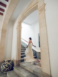 Bride in wedding dress walking upstairs on staircase in hotel