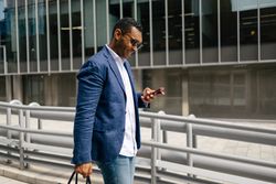 Man walking through financial area with smartphone