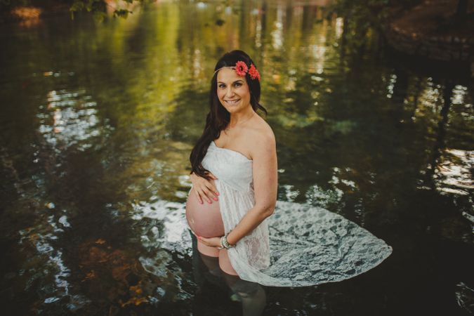 Pregnant woman standing in lake water