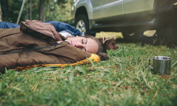 Young woman resting in the nature on sleeping bag