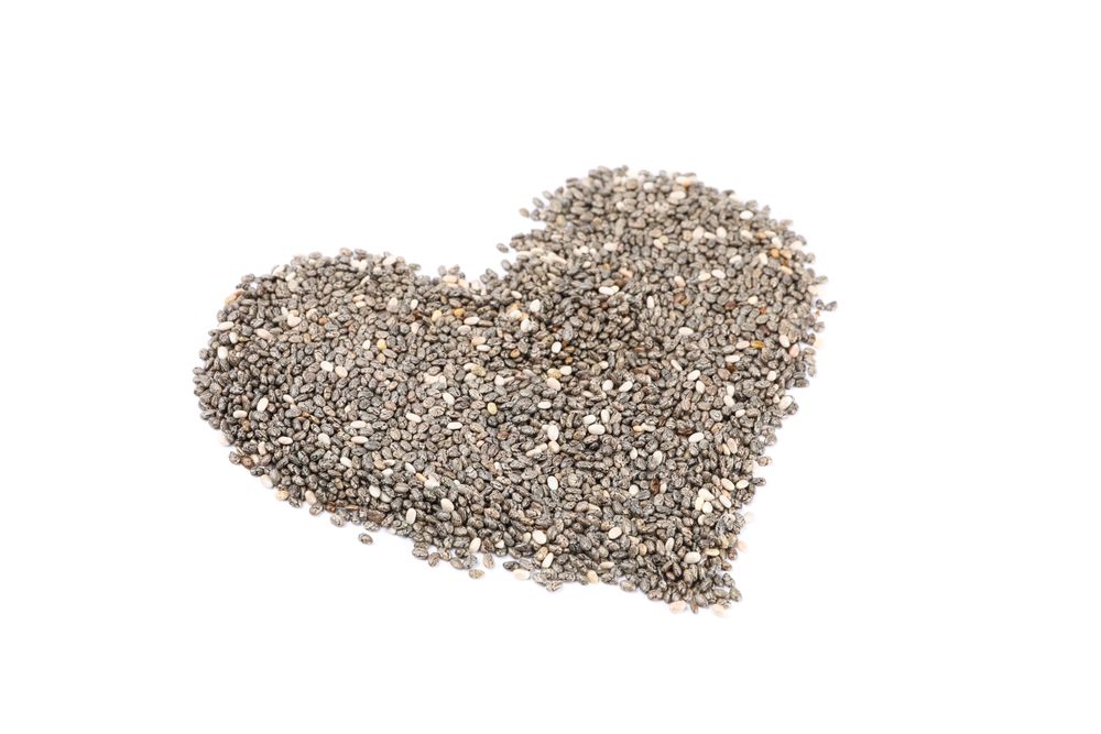 Heart laid out of chia seeds isolated on plain background