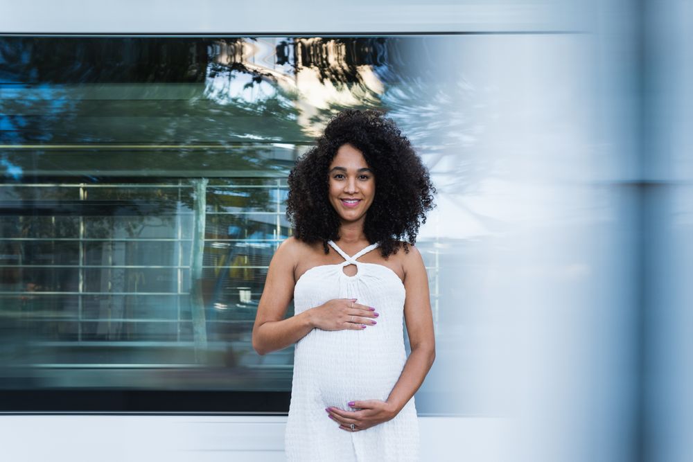 Smiling pregnant woman in long dress