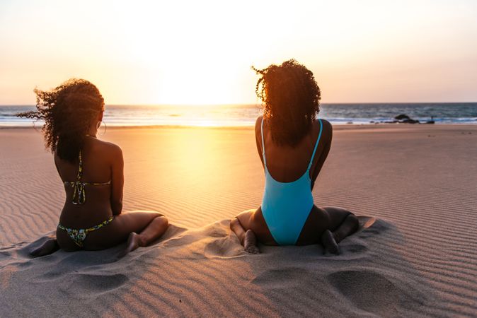 Content Black woman on tropical beach at sunset
