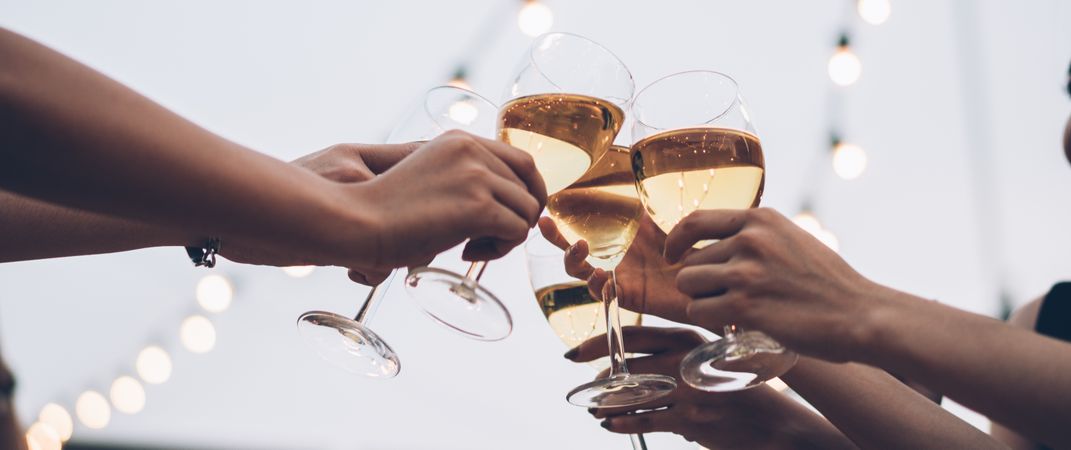 Hands of people toasting glasses of wine at the party outdoors