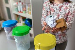 Girl in ecology classroom showing handful of waste to recycle