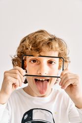 Child posing with his mobile phone and photos made of parts of his face