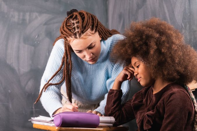 Black schoolgirl and teacher in classroom