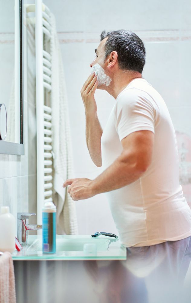 Man applying shaving foam on face