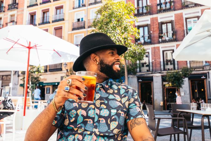 Black man having a drink in a bar terrace
