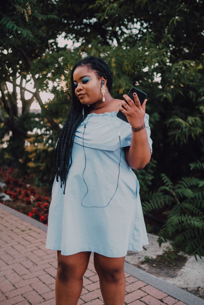 Happy trendy Black woman listening music