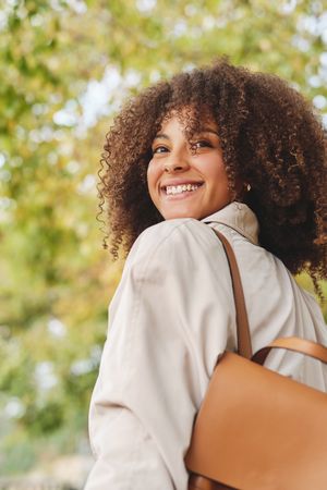 Smiling Black woman with backpack in park