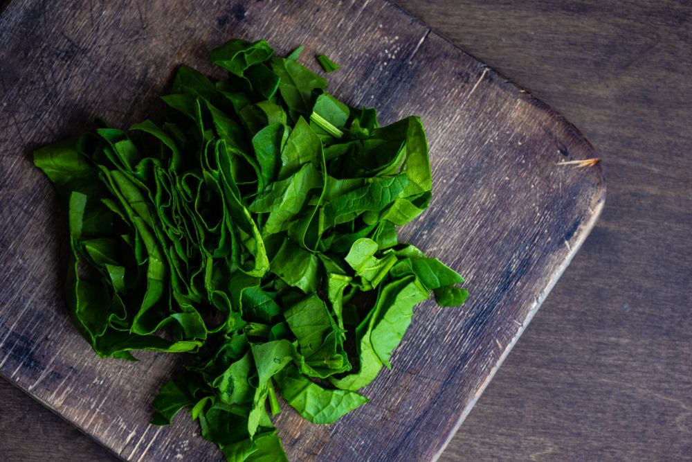 Fresh cut spinach on wooden board
