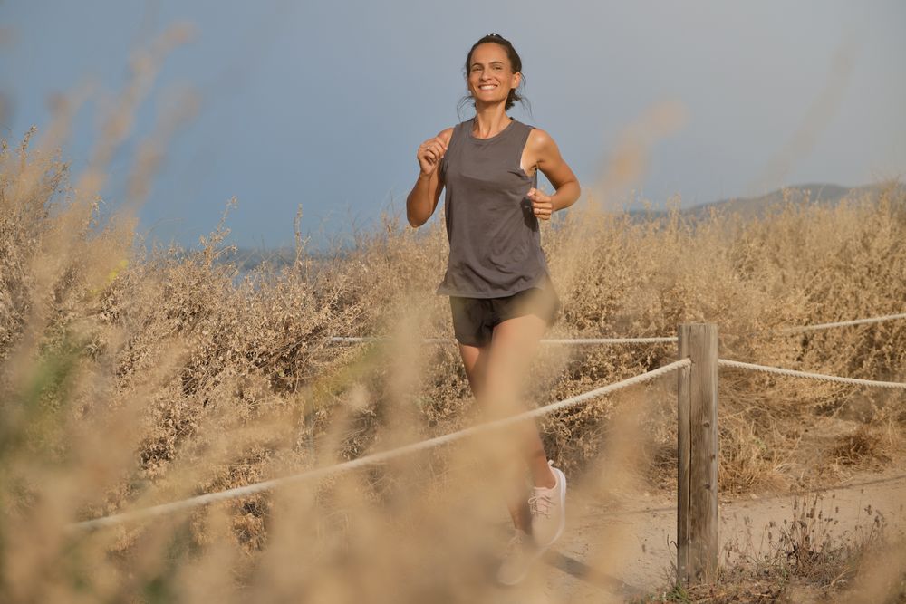 Young woman admiring dry fields while running