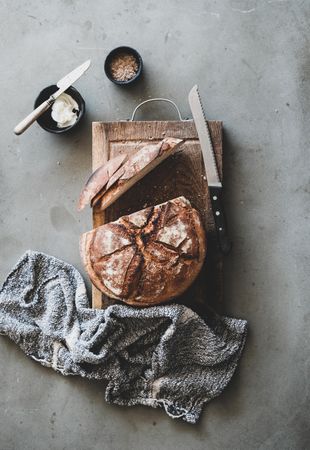 Freshly baked sourdough bread loaf, sliced, vertical composition, with butter