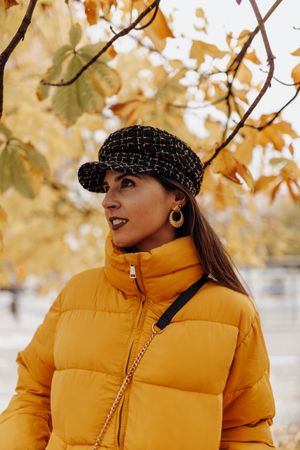 Smiling woman standing on autumn tree
