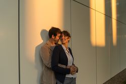Happy couple colleagues hugging on the street