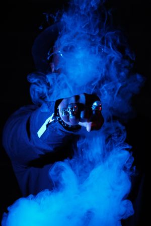 Unrecognizable man punching through vapor