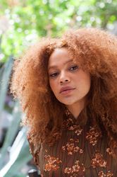 Young woman with afro looking at camera with head tilted