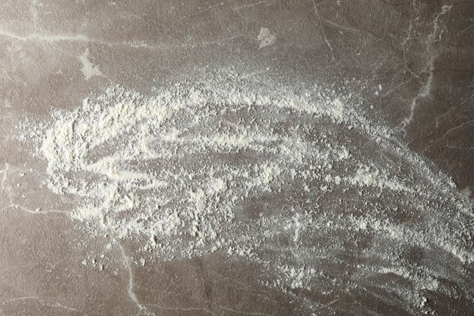 Flour on gray background, top view and space for text