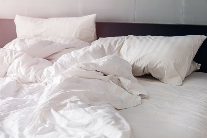 bed and pillows with wrinkle blanket in bedroom, from sleeping in a long night.