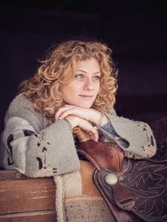 Thoughtful woman leaning on saddle