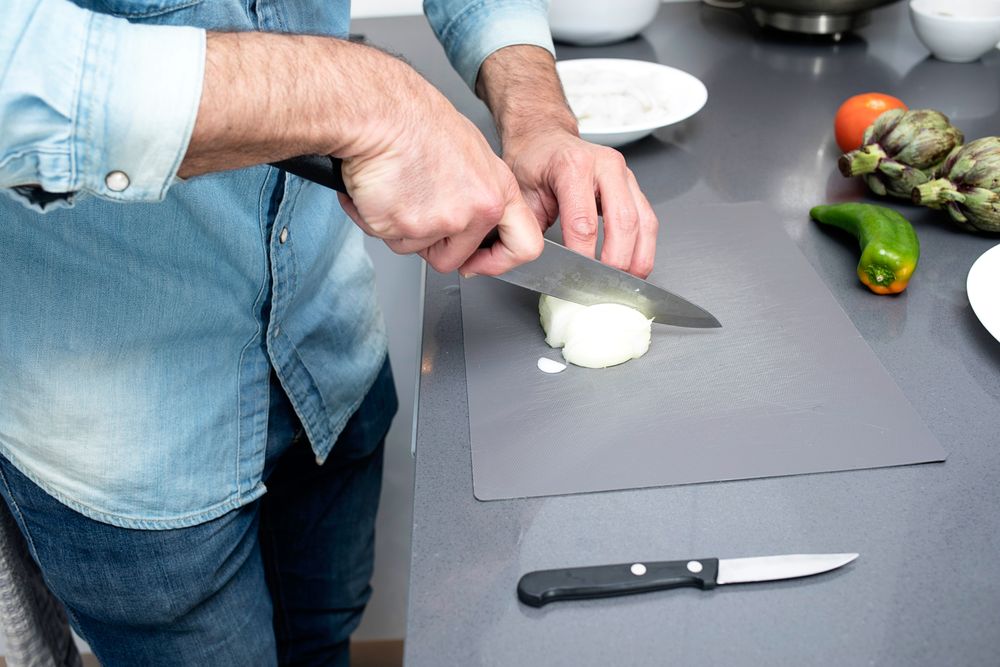 Man chopping onion on board