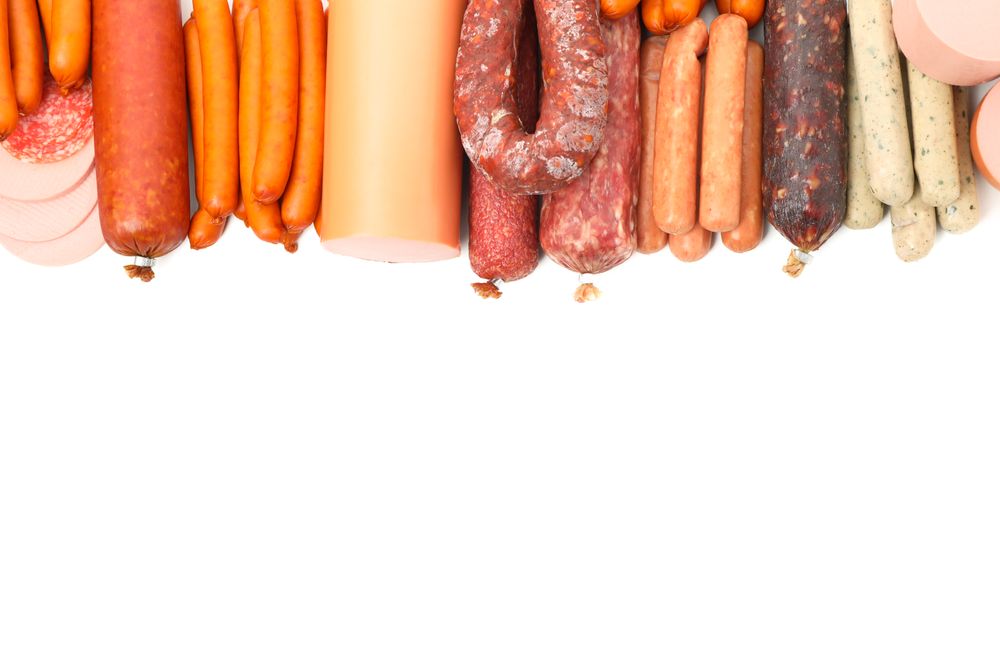 Large variety of cured meats in plain room, copy space