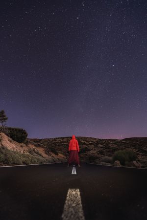 Traveler standing on empty road at night
