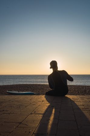 Man practicing paddle surfing with neoprene in a sunrise
