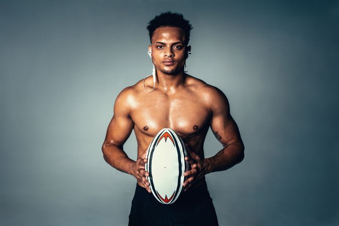 Fit young man holding rugby ball