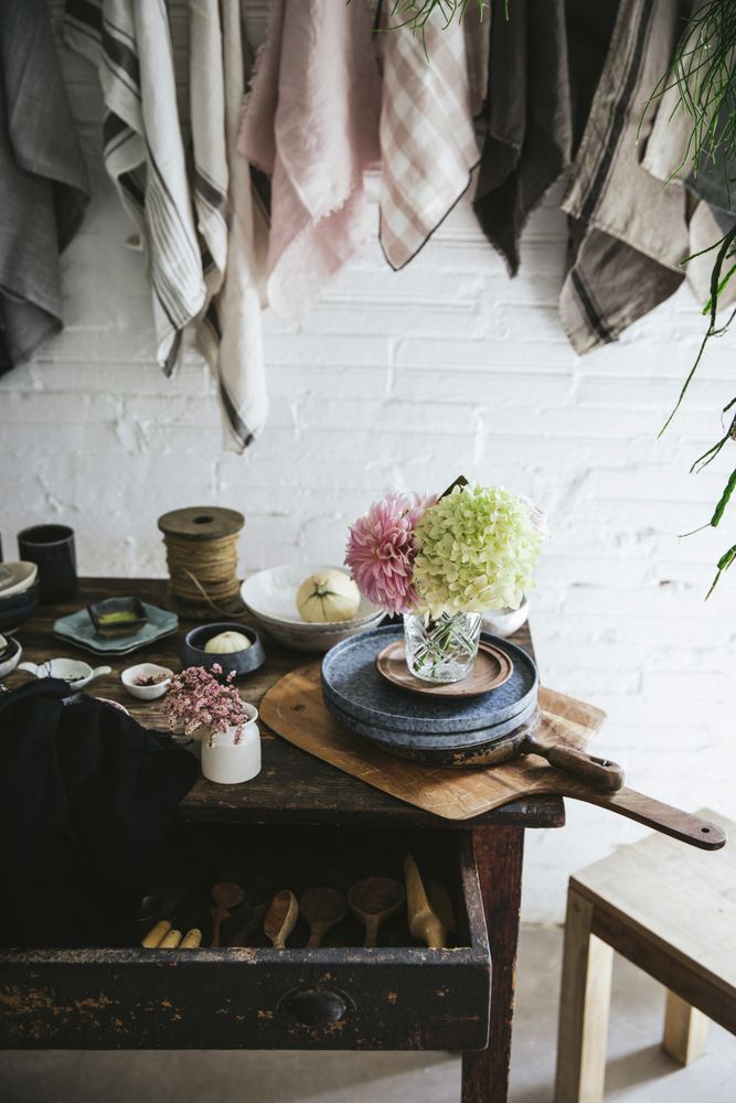 Table with flowers in vase on trays near towels hanging on thread