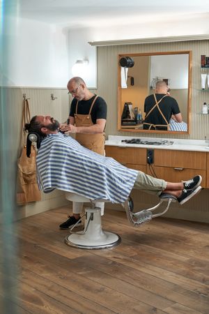 Professional barber cutting hair of client