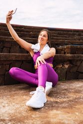 Slim woman in sportswear taking selfie by stone stairs