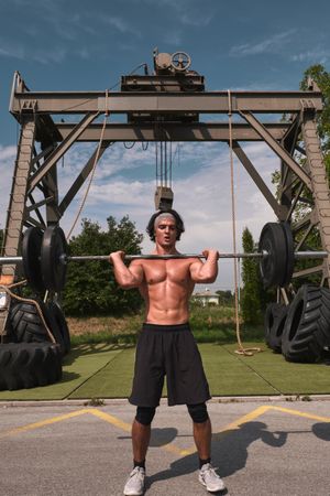 man with barbell in outdoor gym