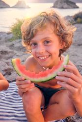 Boy with watermelon slice at seaside