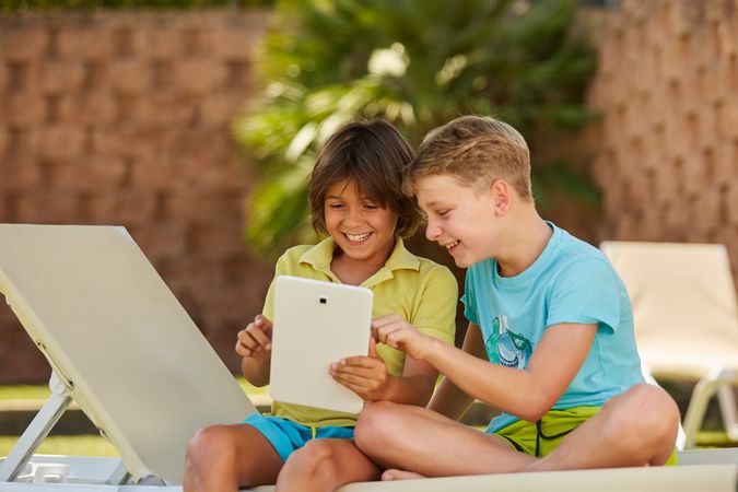 Boys using tablet in garden
