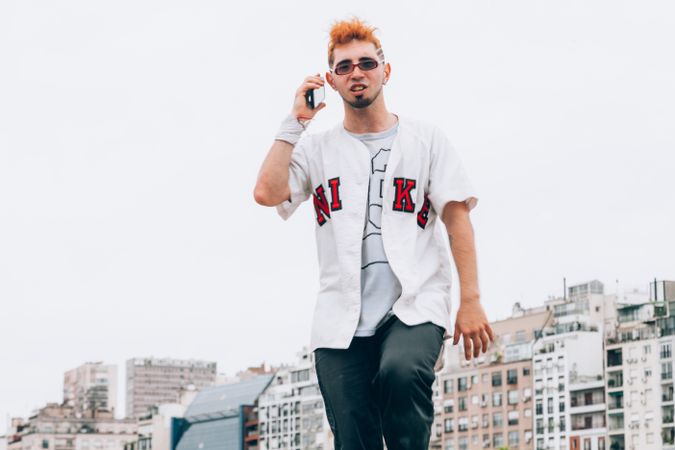 Contemporary male in casual trendy wear calling on smartphone