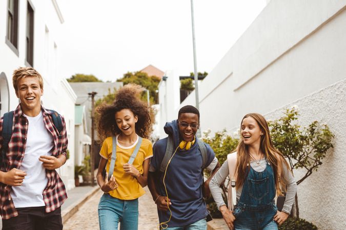 Group of diverse teenage friends enjoying a walk in the street.