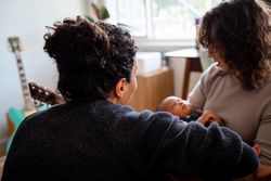 Two mothers rocking baby to sleep