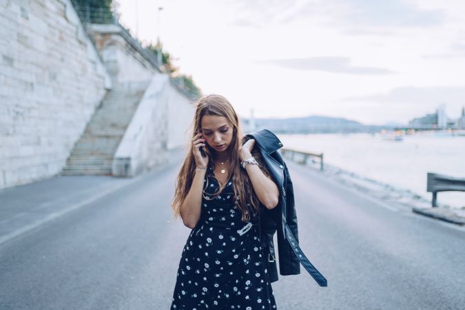 Long haired stylish woman speaking on smartphone