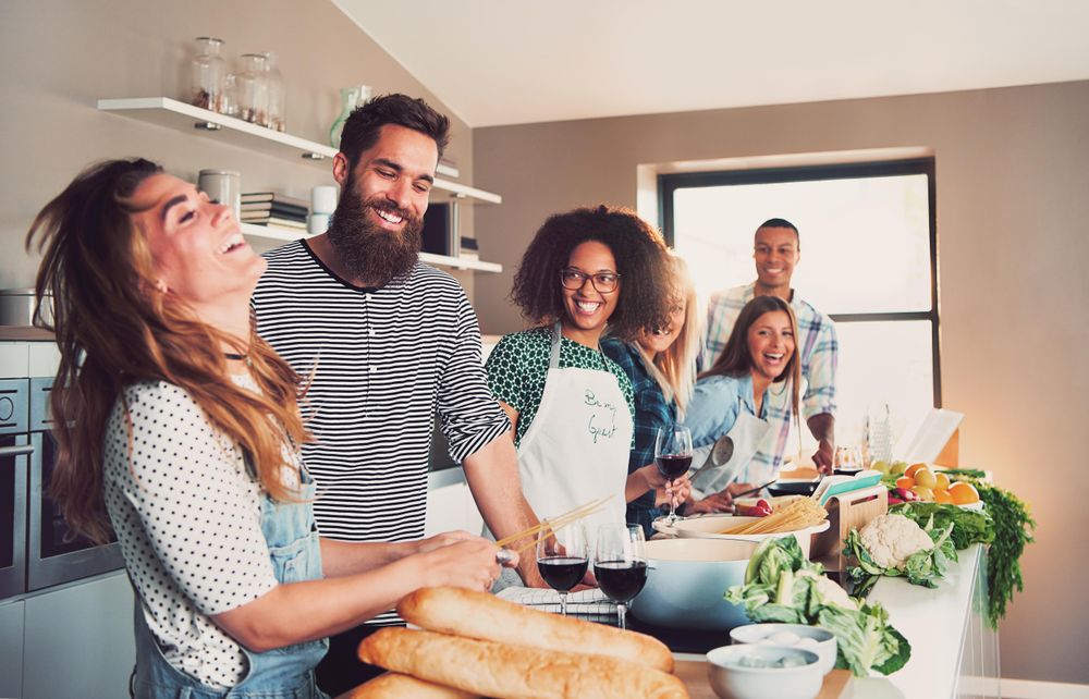 Friends prepare pasta in the kitchen together
